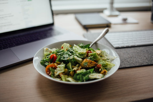 Ensalada saludable junto a laptop - alimentación trabajando desde casa