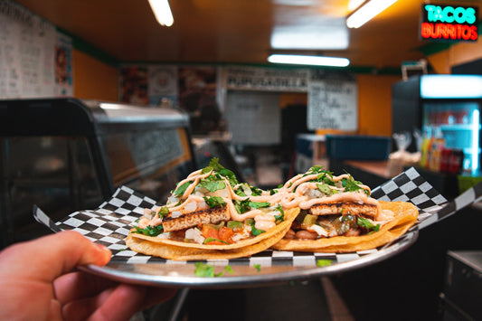 Pollo desmechado servido en taco con vegetales frescos